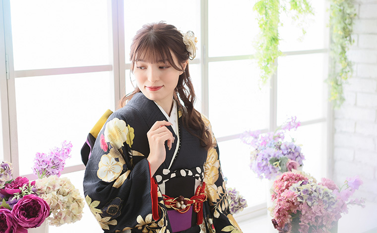 黒の振袖を着て微笑む女性