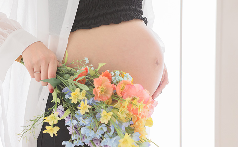 パートナーが妊婦さんのお腹に優しく触れている写真