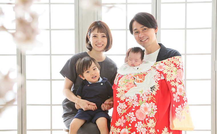 お宮参りの際に赤ちゃんを抱っこする家族