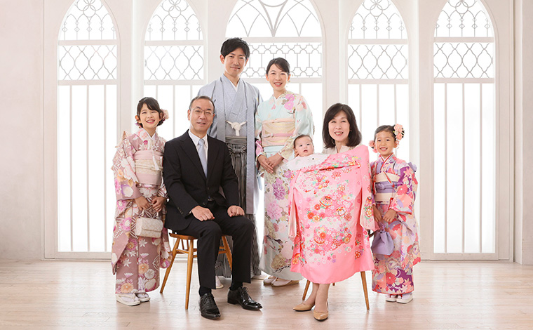 お宮参りの際に家族で写真撮影をする様子