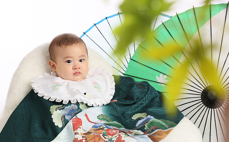 抱っこ紐の上から産着を羽織る様子